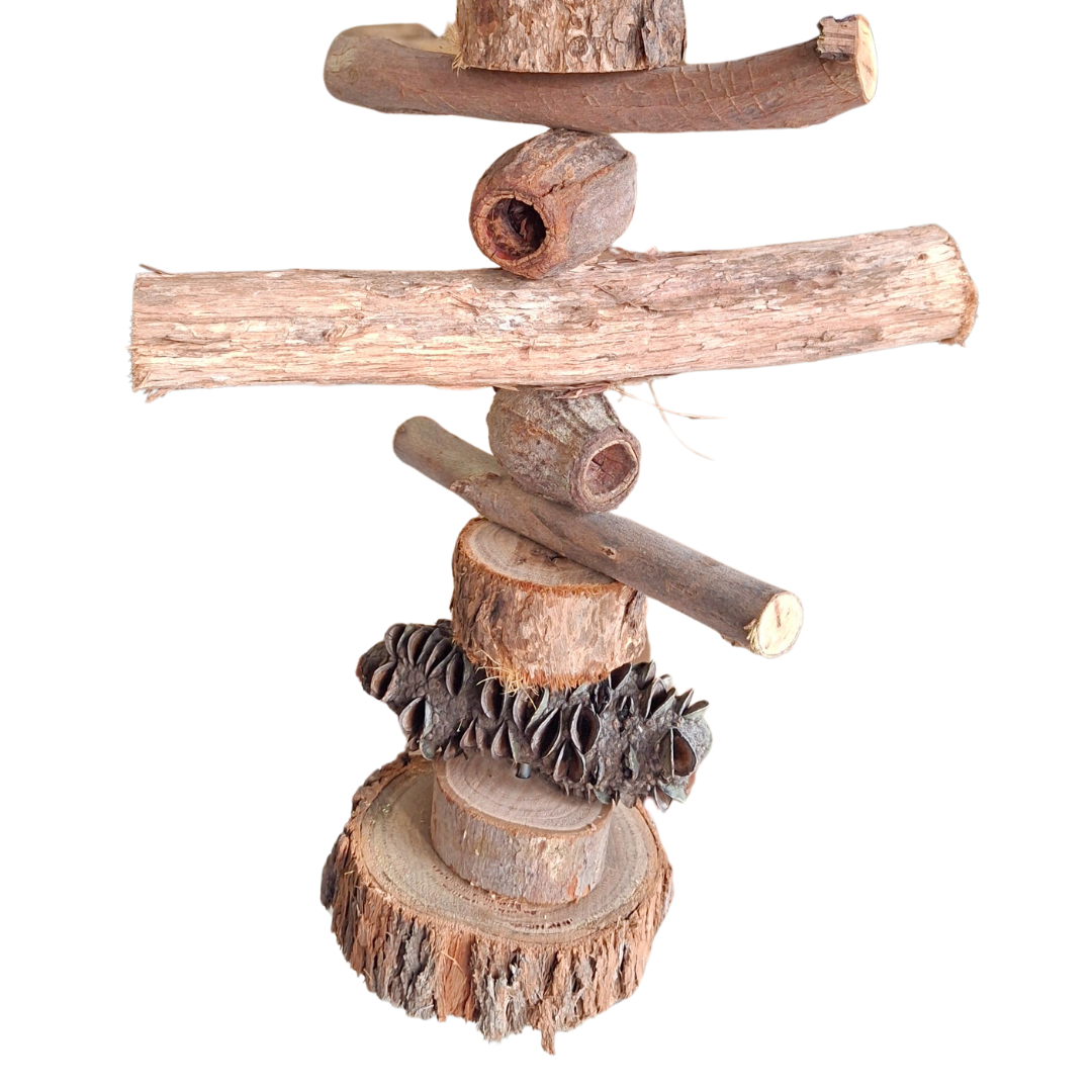Close up of bottom half of the Natural Australia materials including chunky wood slices, gumnuts and banksia pods stacked on a skewer on a white background 