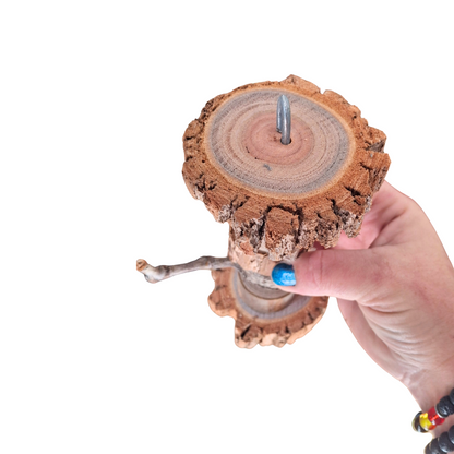Wooden dumbbell bird toy held in hand showing the top side 